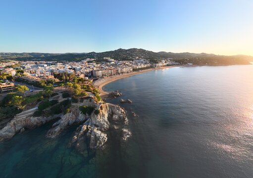 Aerial view taken from a drone of the coast of Lloret de Mar, Costa Brava, Spain, early in the morning at sunrise - the sea, beach and coastal hotels
