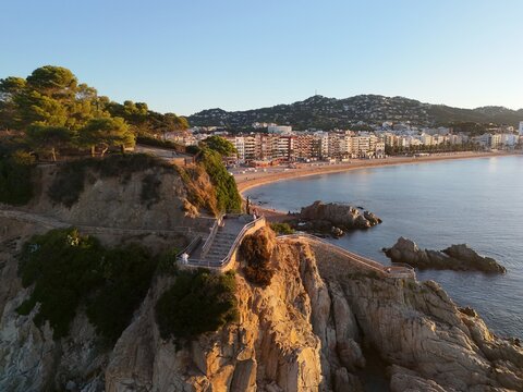 Aerial view taken from a drone of the coast of Lloret de Mar, Costa Brava, Spain, early in the morning at sunrise - the sea, beach and coastal hotels