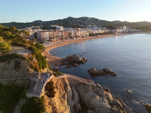 Aerial view taken from a drone of the coast of Lloret de Mar, Costa Brava, Spain, early in the morning at sunrise - the sea, beach and coastal hotels