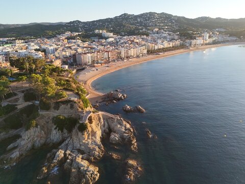 Aerial view taken from a drone of the coast of Lloret de Mar, Costa Brava, Spain, early in the morning at sunrise - the sea, beach and coastal hotels