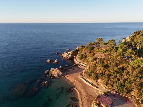 Aerial view taken from a drone of the coast of Lloret de Mar, Costa Brava, Spain, early in the morning at sunrise - the sea, beach and coastal hotels