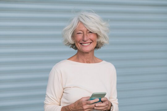 Smiling elderly woman with smartphone closeup portrait for lifestyle website banner and social media use