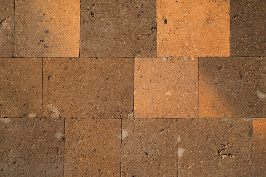 Orange and brown volcanic tuff stone tiles texture background
