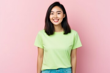 Fototapeta premium Young asian woman posing with a cheerful smile against a pink background