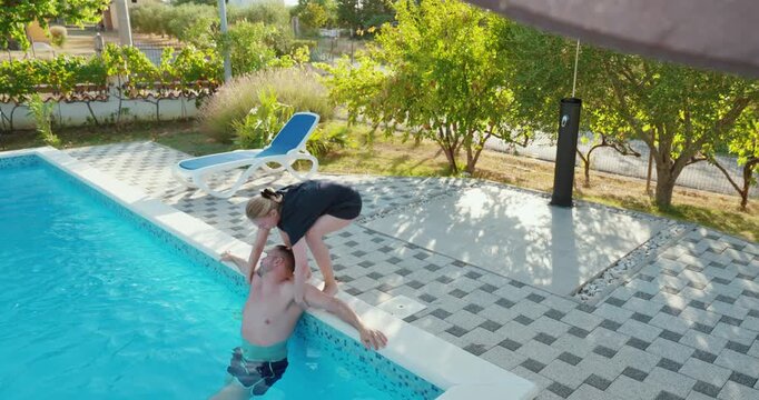 Woman attempting to pull an unconscious man out of a swimming pool during a water emergency, representing drowning rescue, lifesaving assistance and pool safety.
