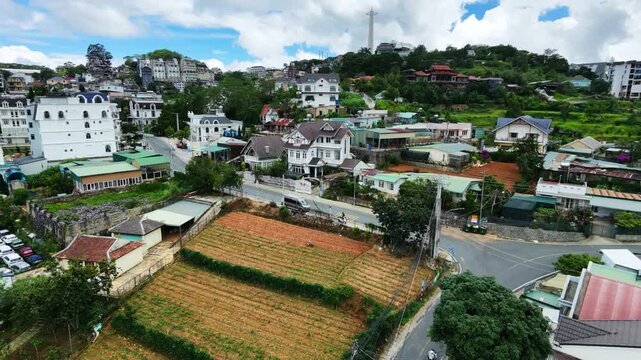Aerial view of rural houses surrounded by greenery and roads on a sunny day