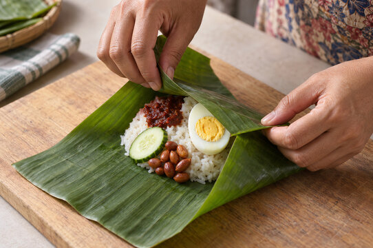 Malaysian Home Cook Wrapping Traditional Nasi Lemak in Fresh Banana Leaf