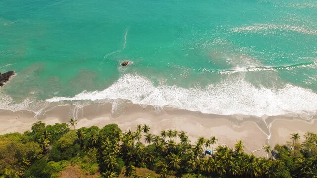Aerial view of Espadilla beach with turquoise water and palm trees in Costa Rica