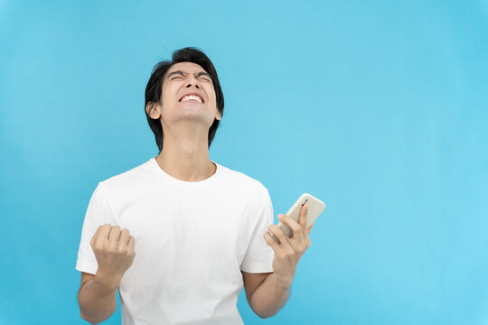 Asian handsome man exited surprise face expression . Male point with the phone. exciting smile and happy adorable rejoices. Very enjoy and fun relax time. wow, girl holding smartphone.