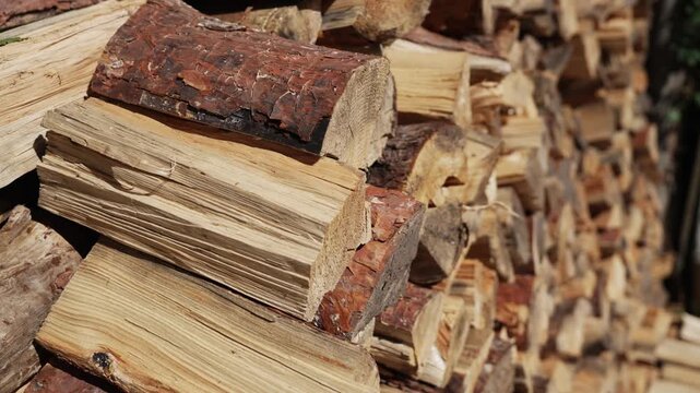 Pile of chopped fire wood prepared for the fireplace and stove. Stacks of fuel wood. Replenishing Stocks of Firewood for Winter. Country life. The chopped trees is stacked in a large log woodpile.