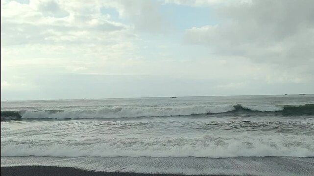 Waves crashing on black sand beach Biaung Beach Bali Indonesia on the beach
