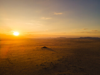 Low sun burning over a hazy desert horizon © Luigi