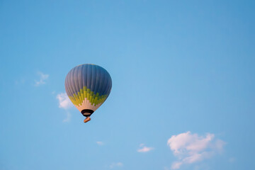 Fototapeta premium Single hot air balloon floating in blue sky over Cappadocia