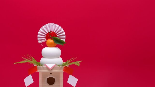 鏡餅を左側に配置し、赤白背景でティルトダウン撮影した動画　三宝あり
