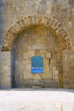 Stone arch framing embrasure in Mamula fortress wall. Portrays Balkan defensive architecture, former concentration camp, World War II historical site in Europe, and dark tourism site in Montenegro.