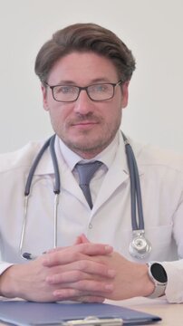 Serious Middle Aged Doctor Looking at the Camera, Vertical Video