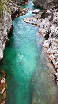 Vertical overhead aerial drone view of the clear emerald water pooling between smooth white rocks, Soca Valley, Slovenia