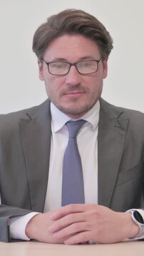 Portrait of Middle Aged Businessman Looking at the Camera in Office, Vertical Video