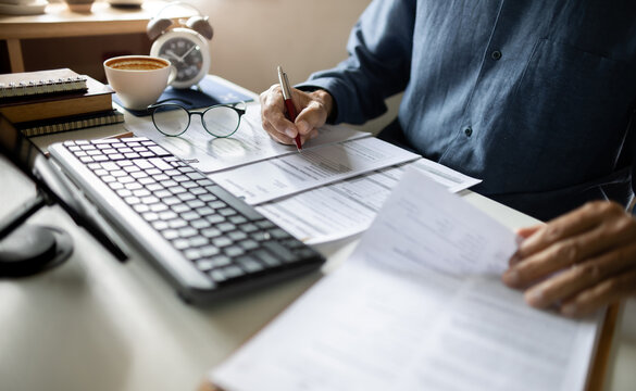 close up shot, asian businessman working on desk reading document contract. legal expert, professional lawyer reading and checking financial document business contract
