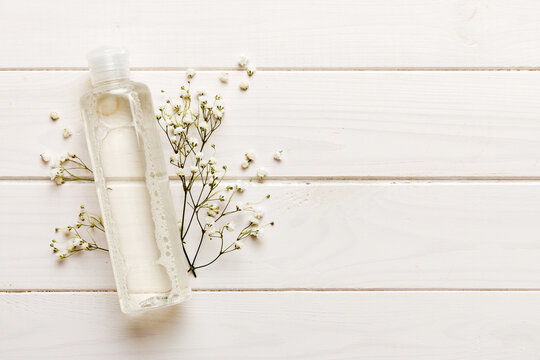 Fancy healthcare bottles for serum, micellar, tonic, toner, lotion, water and cream with gypsophila branch. Natural oranic spa cosmetics concept. Mockup, template, Top view