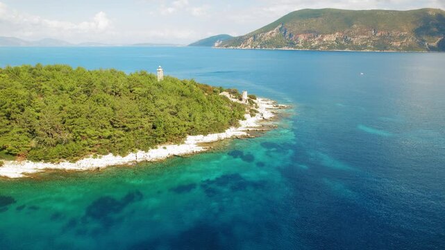 Aerial view of forested coastline and lighthouse near sea waters in Kefalonia Greece