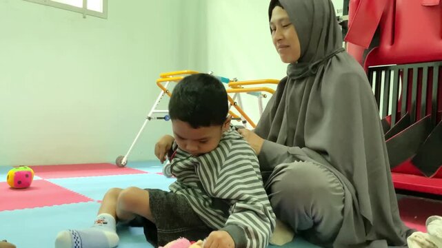 Mother assisting a child with motor impairment in a pediatric rehabilitation clinic