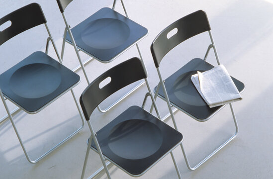 Newspaper on one of four fold up chairs