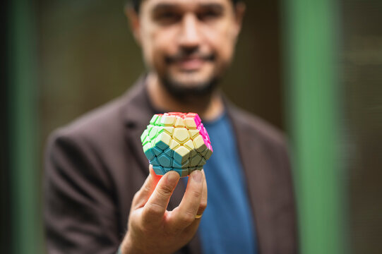 Smiling businessman holds a colorful puzzle to solve a problem