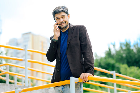Confident businessman has a phone conversation outdoors