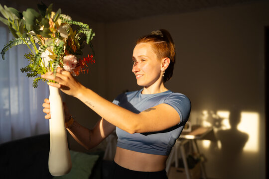 Woman decorates her home with a flower vase indoors