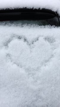 Snow heart shape drawn on a winter day in a snowy outdoor area