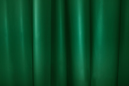 A green fabric curtain creates a textured background