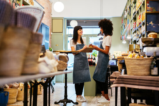 Two smiling women standing in a store with clipboard