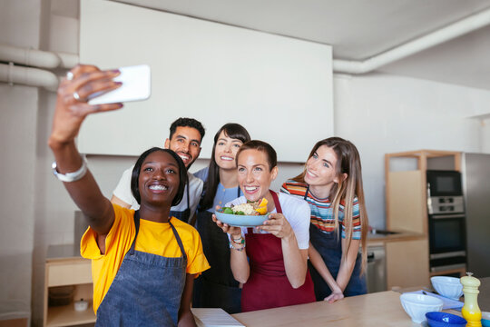Friends and instructor in a cooking workshop taking a selfie