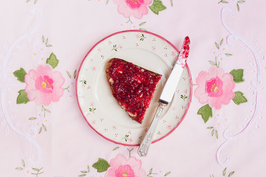 Slice of bread with raspberry jam spread over it
