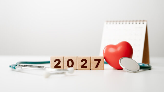 Healthcare and checkup planning concept for 2027 with wooden number blocks, stethoscope, red heart and calendar, medical goals, wellness management, and future healthcare strategies. health insurance
