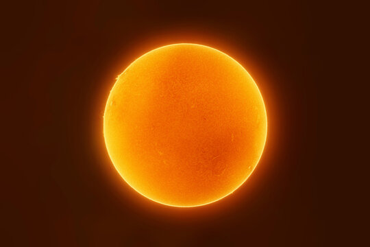 The bright orange sun glows against a dark space background
