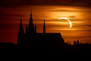 Solar eclipse, Moon in front of the sun low above the horizon in the evening at sunset. In the foreground silhouette of St. Vitus Cathedral at Prague Castle in Prague, Czech Republic, June 12. 2026 © ondrejprosicky