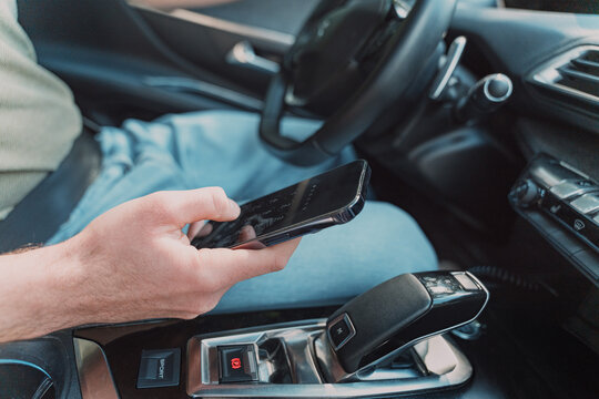 Man checks his smartphone while stopping his car in traffic