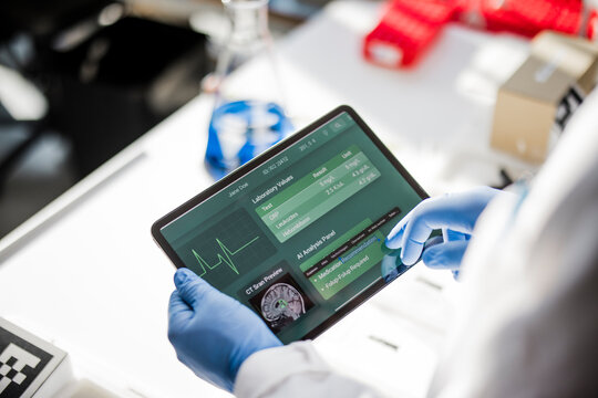 Male scientist analyzing medical information on a tablet in lab