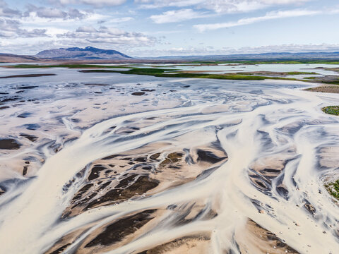 Glacial meltwater of Hv�t� River flows through dark sand in Iceland