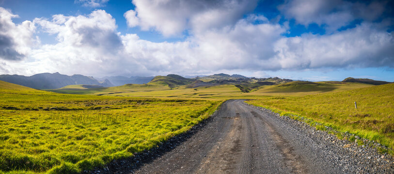 Gravel road curves through a mossy landscape in Katla Geopark