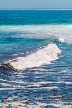 A large wave breaks on the Atlantic coast of Praia da Lagoa