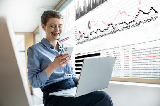 Businesswoman analyzes finance data on smartphone at the office