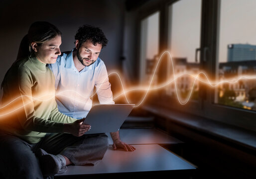 Man and woman analyze digital data on a laptop in the office