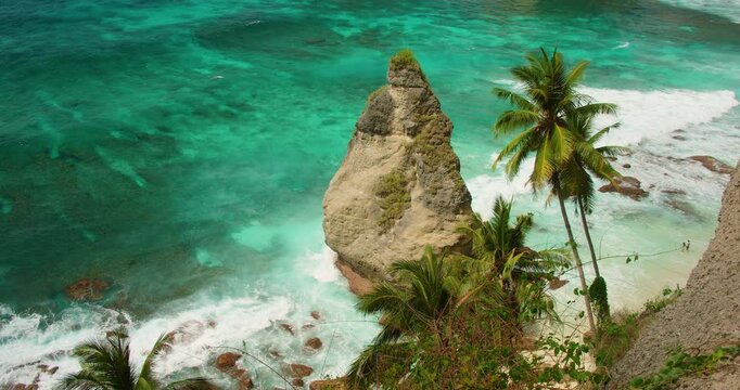 Pointed rock island amidst crashing ocean waves near the shore of Diamond Beach Bali