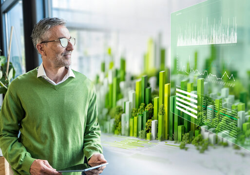 Man in office analyzes green sustainability AI hologram on tablet