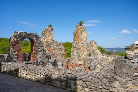 Boskovice Castle ruins stand tall in Czechia. Visitors explore the old stone walls and enjoy the clear blue sky. The history of the site is evident all around with nature taking over.