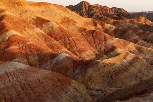 Layered red rock formations in a desert landscape at sunset