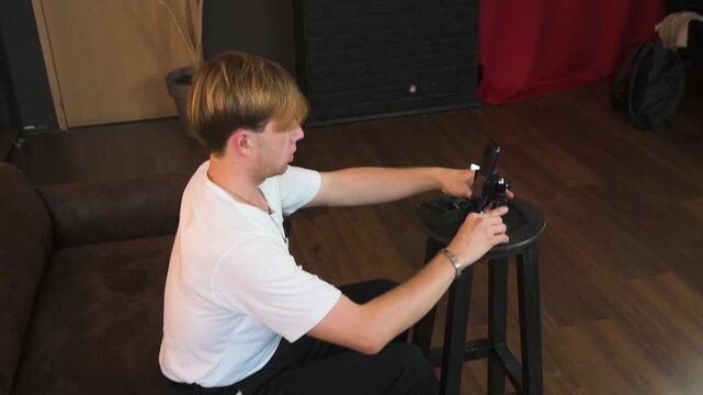 Young Content Creator Setting Up Smartphone on Mini Tripod for Video Recording Indoors